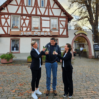 Foto vor dem Gebäude des zukünftigen DIE BIERMACHER. Brauereigasthof "Löwe" in Seeheim. V.l.n.r.: Nadine Höpfner (Kaufmännische Leitung), Ralf Schuchmann (Geschäftsführer), Caroline Maiwald (Marketingleitung) der Die Biermacher GmbH